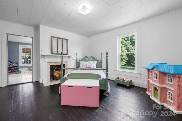 bedroom featuring multiple windows, dark hardwood / wood-style flooring, and ornamental molding