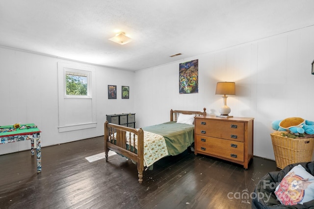 bedroom with dark hardwood / wood-style flooring