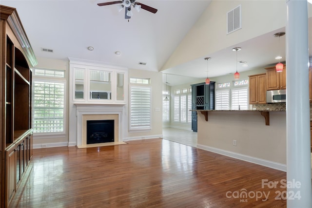 unfurnished living room with ceiling fan, dark hardwood / wood-style flooring, and high vaulted ceiling