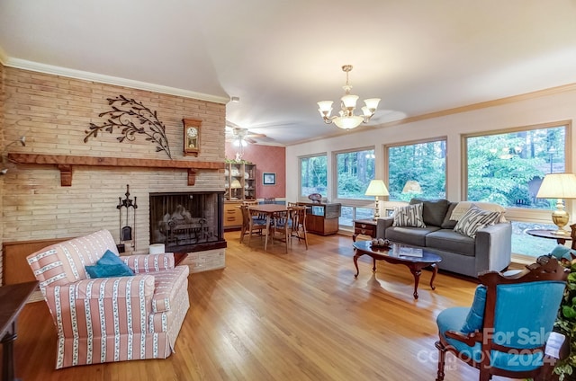 living room featuring a brick fireplace, ceiling fan with notable chandelier, hardwood / wood-style flooring, and crown molding