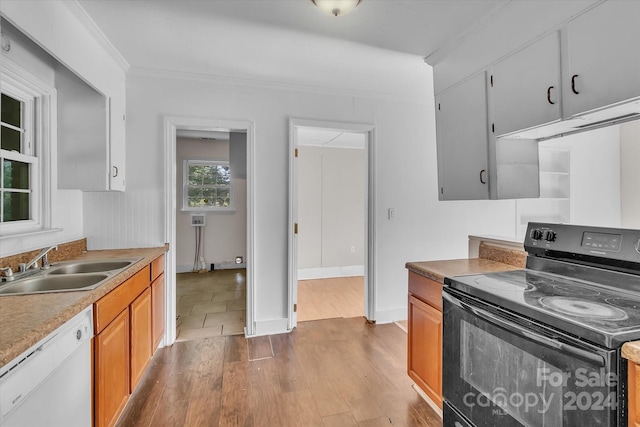 kitchen with sink, light hardwood / wood-style flooring, black range with electric stovetop, white dishwasher, and ornamental molding