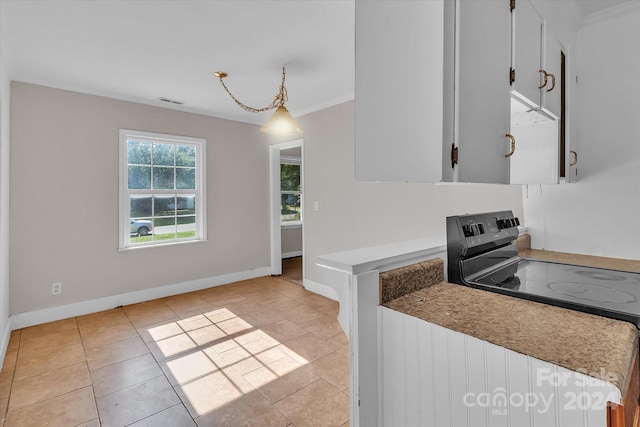 kitchen featuring decorative light fixtures, white cabinets, light tile patterned floors, crown molding, and black electric range