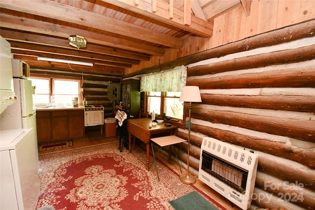 interior space featuring beamed ceiling, sink, rustic walls, stacked washer / dryer, and wood-type flooring