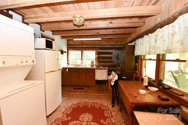 kitchen featuring stacked washer / dryer, light hardwood / wood-style flooring, white appliances, and beam ceiling