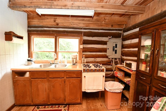 kitchen with light hardwood / wood-style floors, sink, beam ceiling, and tankless water heater