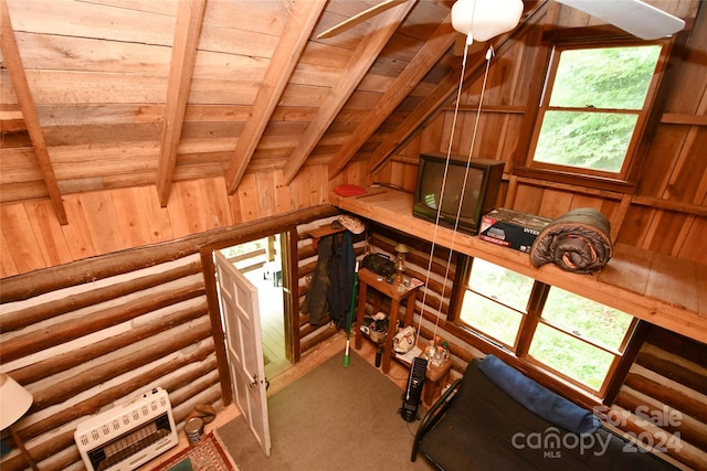 interior space featuring beamed ceiling, a wealth of natural light, wooden ceiling, and wooden walls