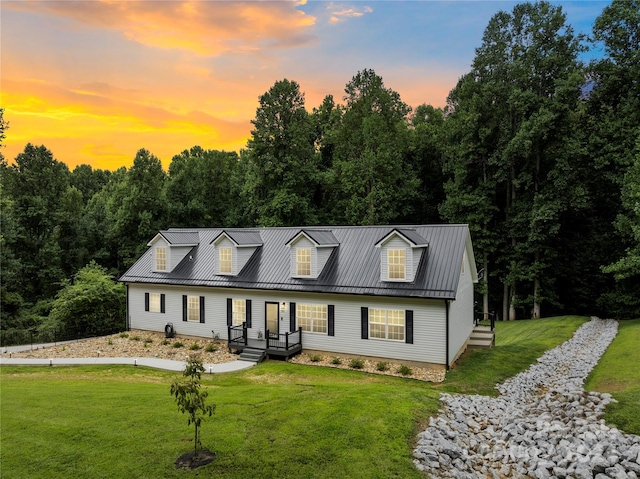 cape cod house with a lawn