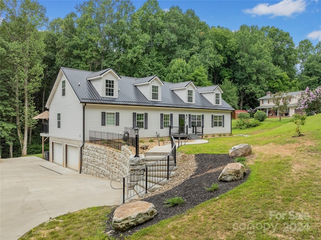 cape cod house with a garage and a front lawn