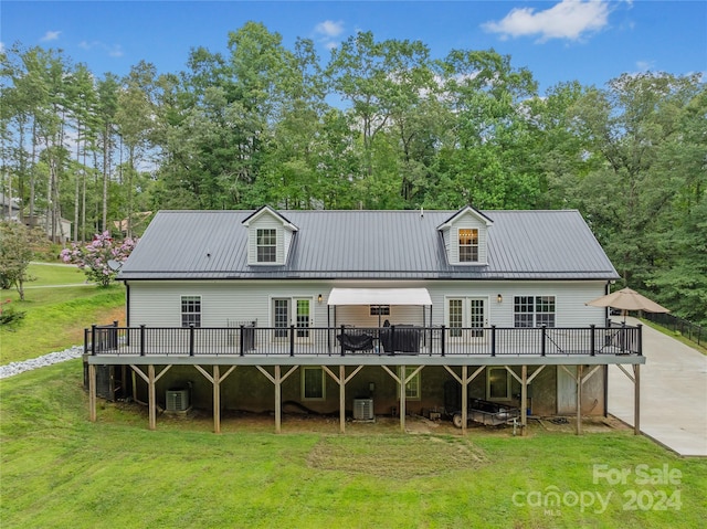 exterior space with central AC unit, a wooden deck, and a front lawn