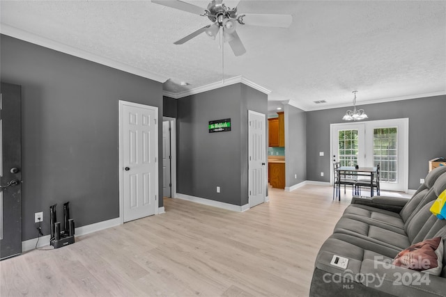 living room with ceiling fan with notable chandelier, crown molding, light wood-type flooring, and a textured ceiling