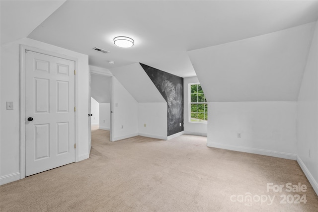 bonus room featuring light carpet and vaulted ceiling