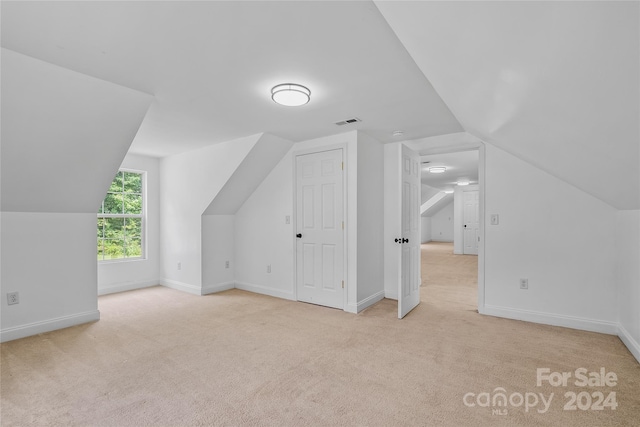 bonus room featuring lofted ceiling and light colored carpet