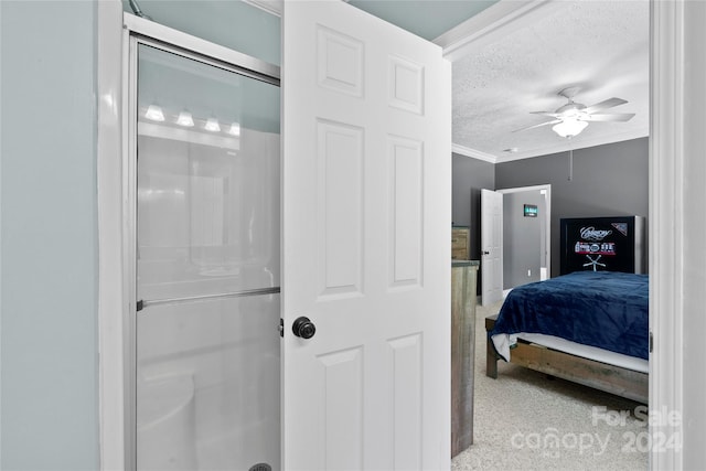 bedroom with ensuite bath, carpet, crown molding, a textured ceiling, and ceiling fan