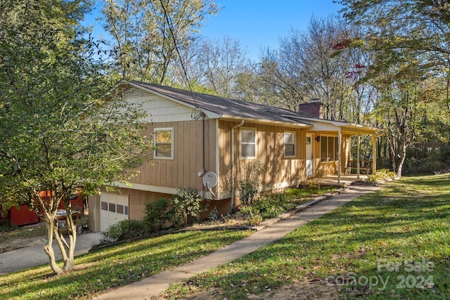 view of front of house with a front yard, a porch, and a garage