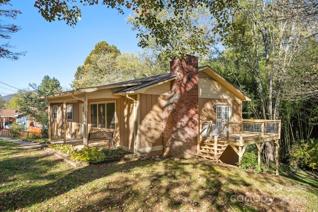 rear view of house with a deck and a lawn