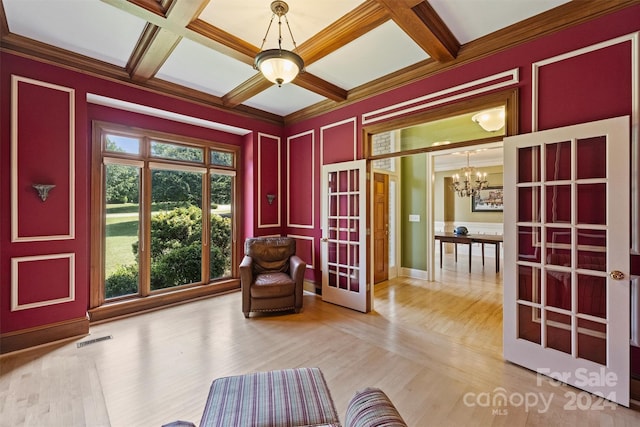 unfurnished room with coffered ceiling, french doors, a chandelier, visible vents, and wood finished floors