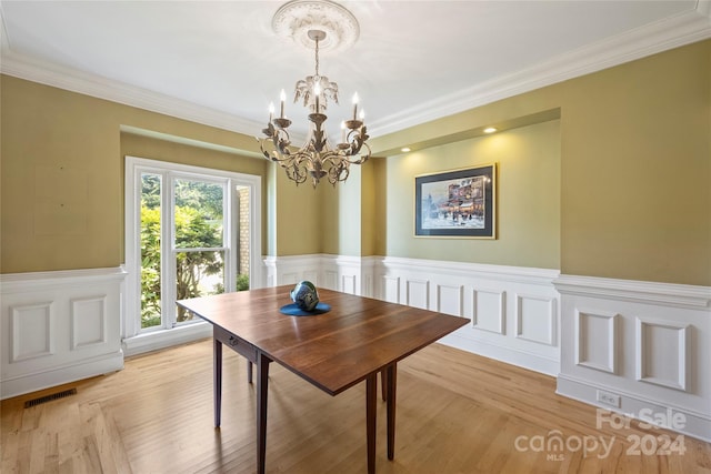 dining space with light wood-type flooring, a wealth of natural light, and a chandelier