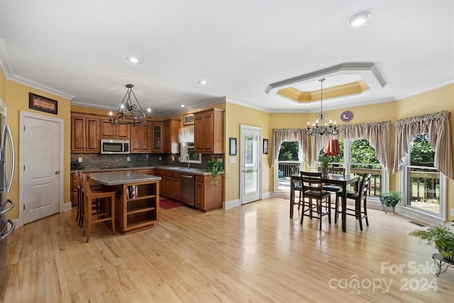 kitchen featuring a notable chandelier, sink, a center island, appliances with stainless steel finishes, and light hardwood / wood-style floors