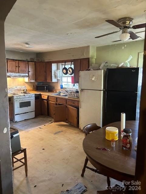 1713 Island Rd, Georgetown, SC 29440 - kitchen with gas range gas stove, freestanding refrigerator, extractor fan, a ceiling fan, and brown cabinets