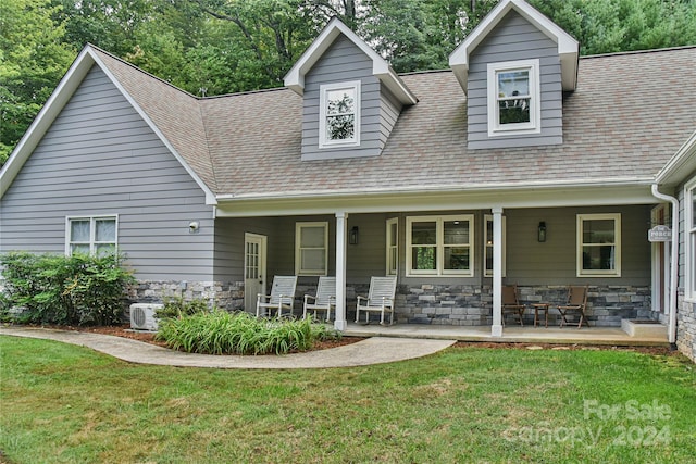 cape cod home with a porch and a front lawn