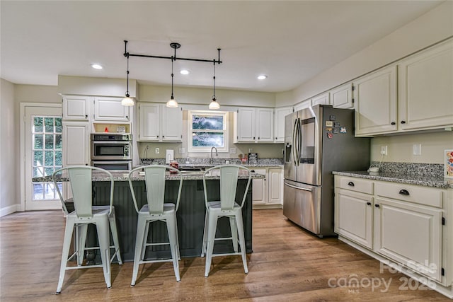 kitchen featuring light stone counters, stainless steel fridge with ice dispenser, and white cabinets