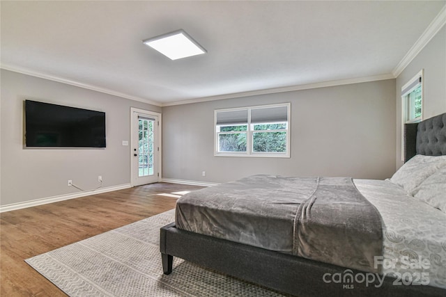 bedroom with wood-type flooring, access to exterior, and crown molding