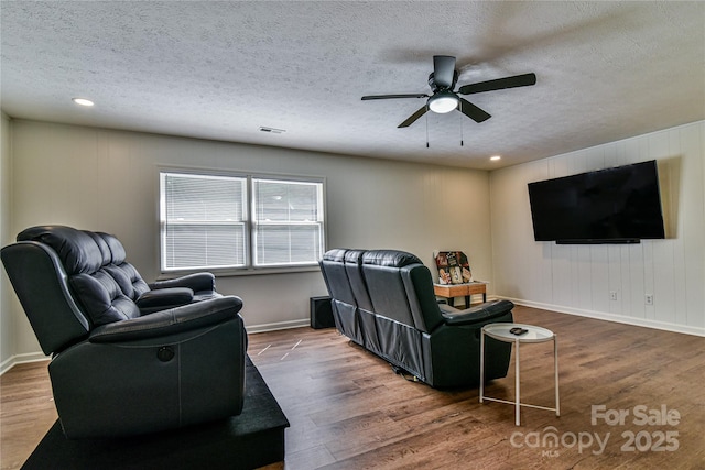 living room featuring a textured ceiling, dark hardwood / wood-style floors, and ceiling fan