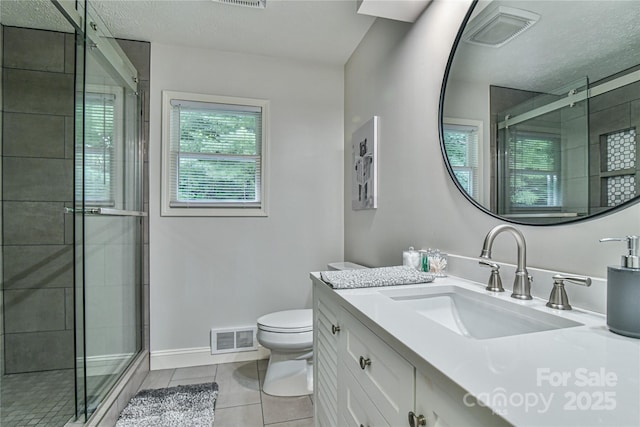 bathroom with vanity, tile patterned floors, toilet, and walk in shower