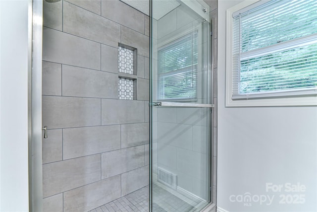 bathroom featuring a shower with door