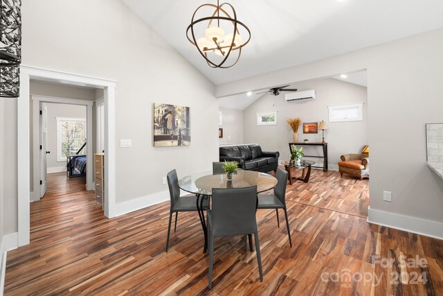 dining area featuring ceiling fan with notable chandelier, dark hardwood / wood-style floors, a wall mounted AC, and lofted ceiling