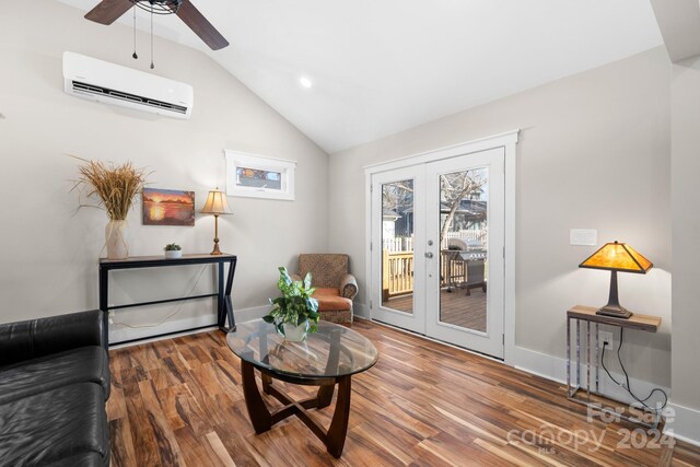 living area featuring a wall mounted air conditioner, ceiling fan, lofted ceiling, and hardwood / wood-style floors