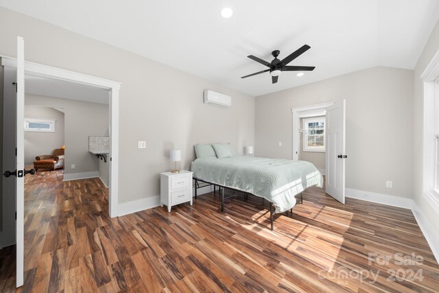 bedroom with dark hardwood / wood-style floors, a wall unit AC, ceiling fan, and lofted ceiling