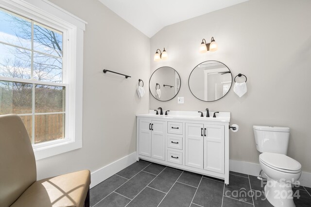 bathroom featuring tile patterned flooring, vanity, lofted ceiling, and toilet