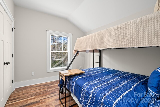 bedroom featuring dark hardwood / wood-style floors and lofted ceiling