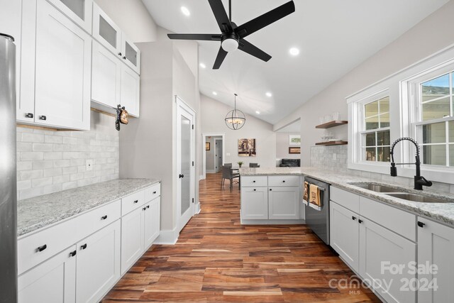 kitchen featuring stainless steel appliances, vaulted ceiling, dark wood-type flooring, sink, and white cabinetry