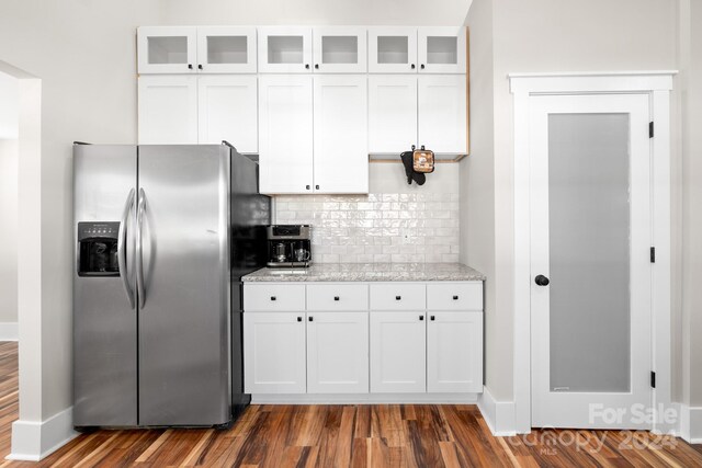 kitchen featuring white cabinets, stainless steel refrigerator with ice dispenser, backsplash, and dark wood-type flooring