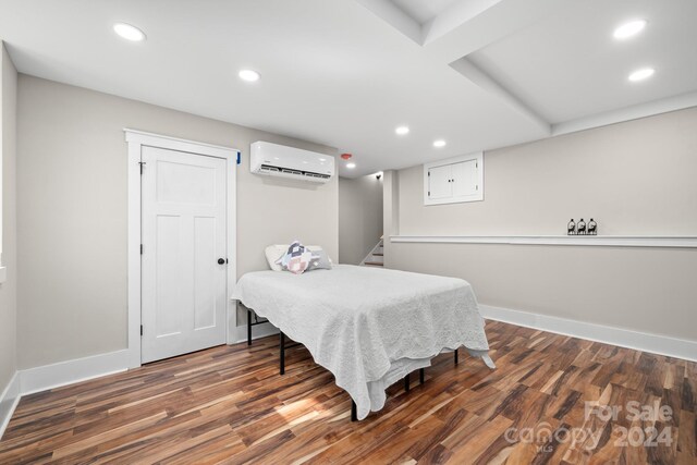 bedroom featuring a wall mounted AC and dark wood-type flooring