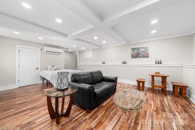 living room featuring beamed ceiling, wood-type flooring, a wall unit AC, and coffered ceiling