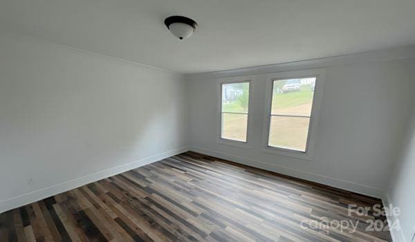 empty room with dark hardwood / wood-style flooring