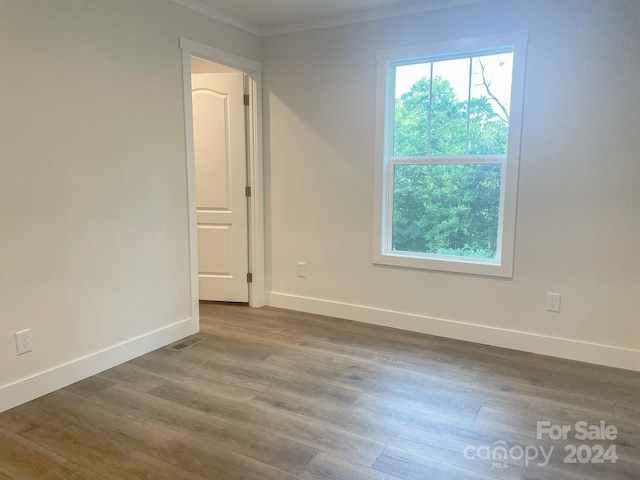 spare room featuring hardwood / wood-style floors and ornamental molding