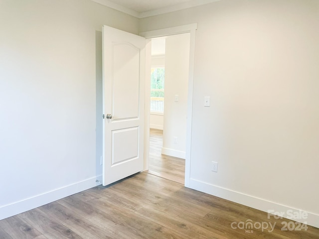 unfurnished room featuring light hardwood / wood-style floors and ornamental molding