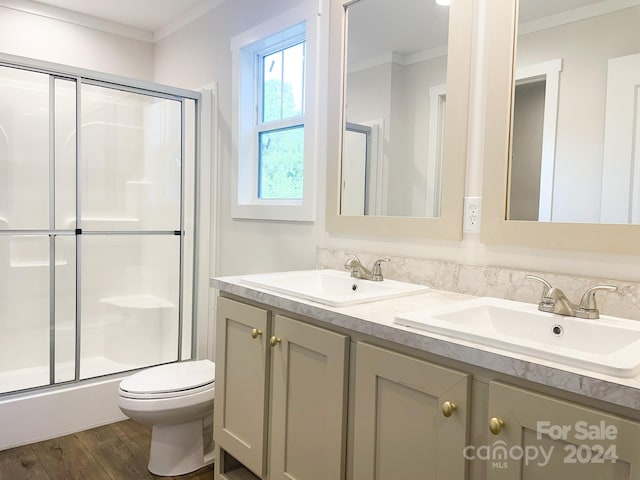 bathroom with an enclosed shower, ornamental molding, vanity, hardwood / wood-style flooring, and toilet