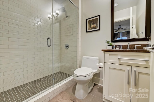 full bath with toilet, a stall shower, tile patterned floors, and vanity