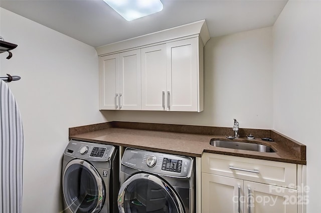 laundry area featuring washing machine and clothes dryer, a sink, and cabinet space