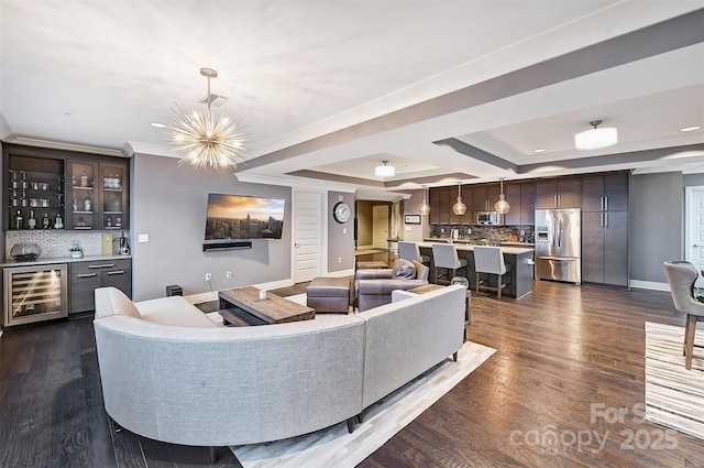 living room featuring baseboards, wine cooler, dark wood-style flooring, a tray ceiling, and a bar