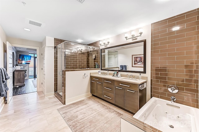 bathroom featuring double vanity, a shower stall, visible vents, and a sink