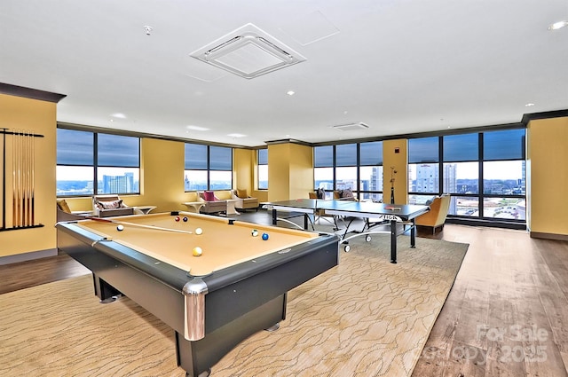 playroom featuring light wood finished floors, expansive windows, visible vents, and a city view