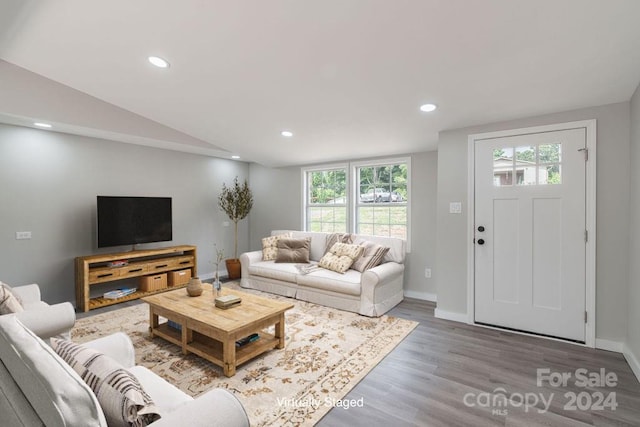 living room with vaulted ceiling, plenty of natural light, and hardwood / wood-style floors