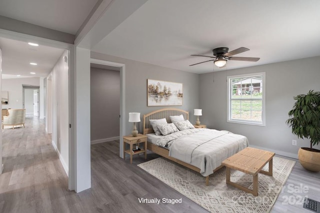 bedroom with dark hardwood / wood-style flooring and ceiling fan