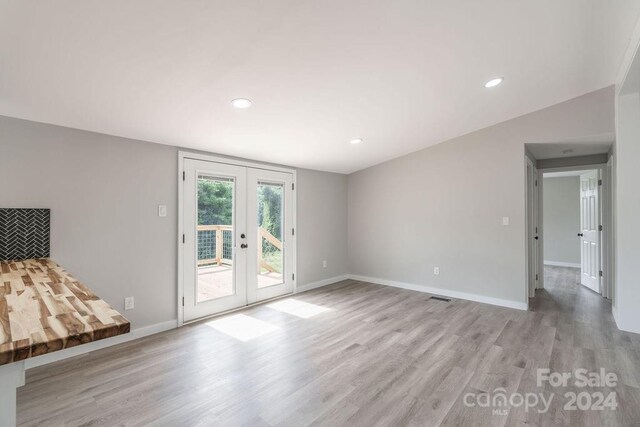 unfurnished living room with french doors and light wood-type flooring